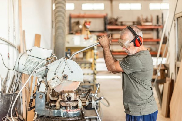 Worker in safety equipment cutting a stainless tube